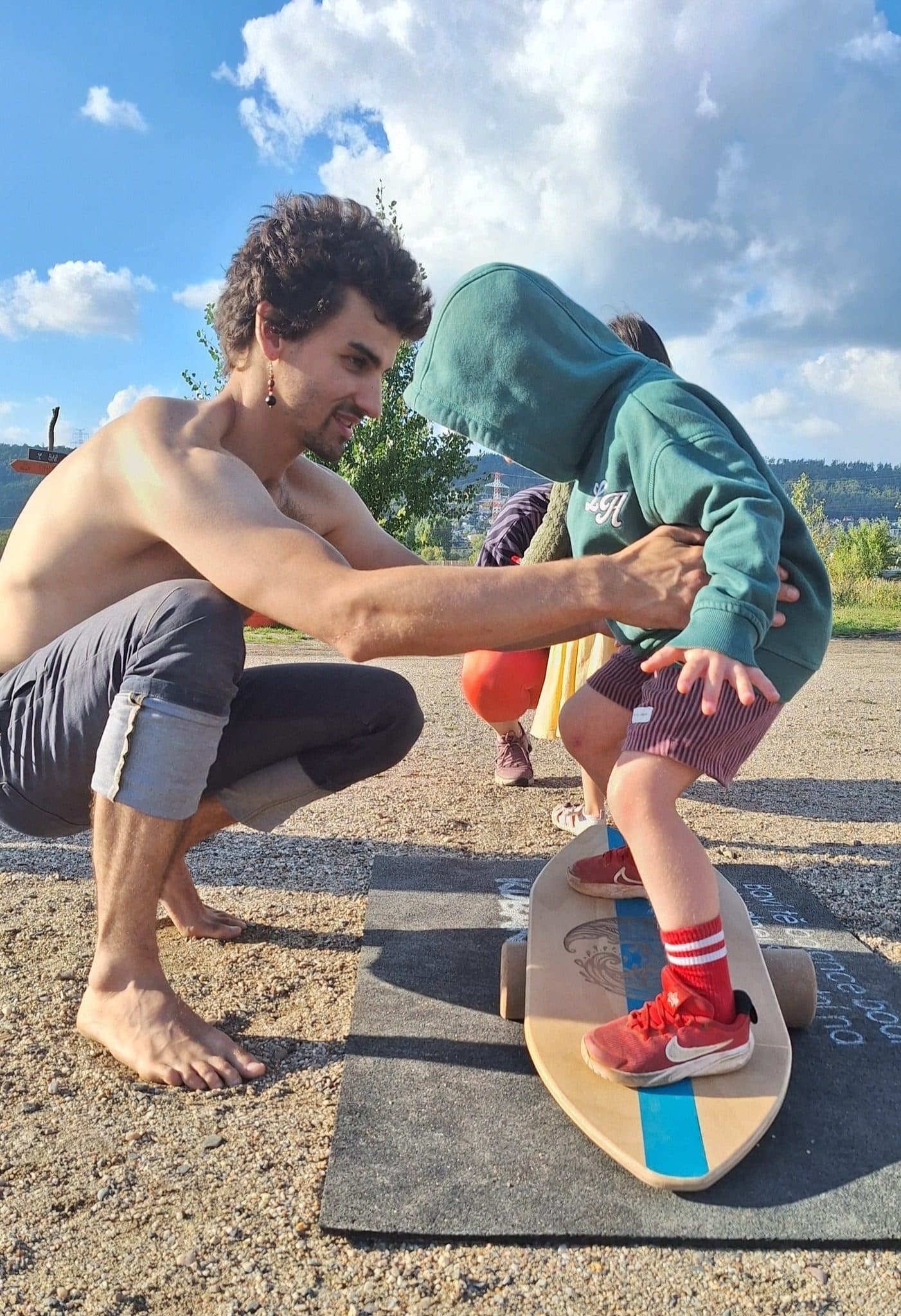 Lektor pomáhá dítěti s balancováním na skateboardu