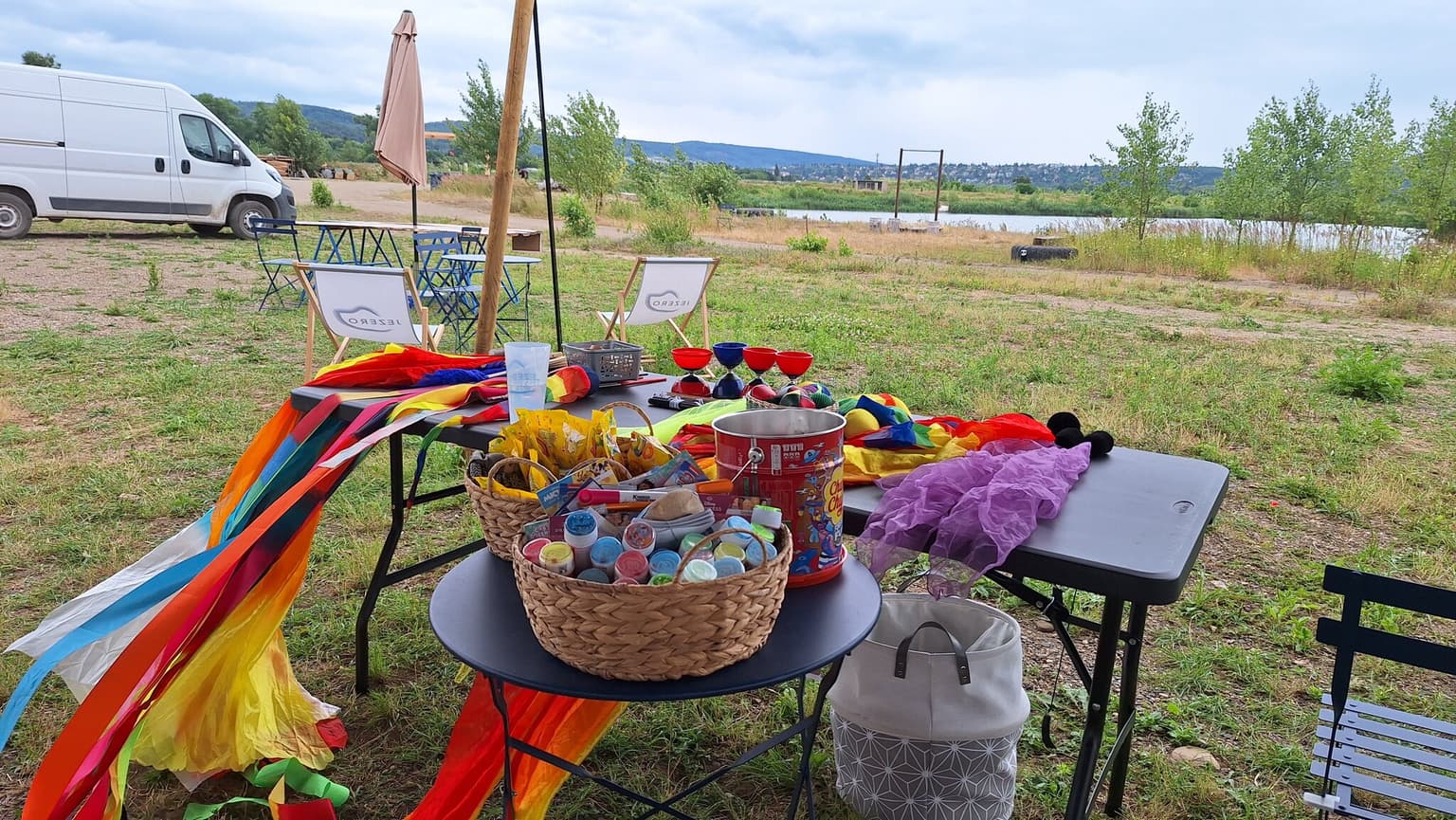 Stůl s výtvarnými a žonglérskými pomůckami připravený u jezera